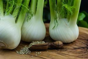 bulbos de erva-doce verde e branco em madeira de oliveira foto