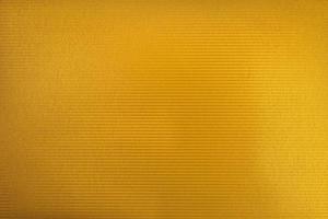 textura de papelão de cor dourada. brilho de cor dourada com luz foto