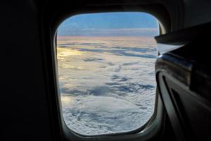 vista aérea do céu azul com nuvens do voo a jato de janela foto