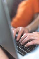 mãos femininas no teclado, a garota trabalha em um laptop e digita foto
