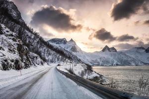 estrada rural no vale de neve no litoral ao pôr do sol foto