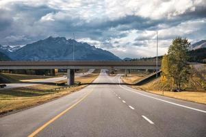 viagem de viagem dirigindo na estrada com montanhas rochosas e céu nublado no parque nacional de banff foto