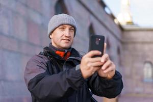 retrato de um homem adulto com um chapéu cinza e jaqueta no fundo da parede foto