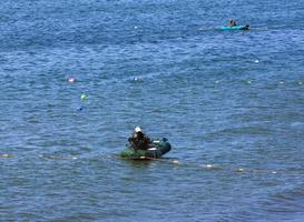 o pescador no barco de borracha pega rede de salmão no oceano pacífico foto