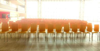 sala de conferências com cadeiras, piso de concreto e janelas. foco seletivo foto