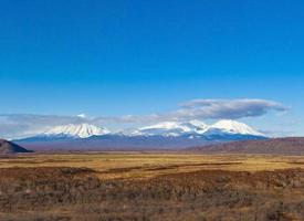 três vulcões na península de kamchatka foto