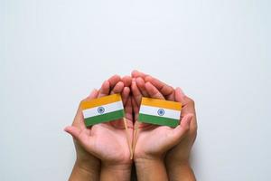 mão segurando e tocando a bandeira nacional da índia foto