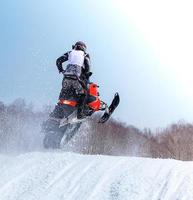 moto de neve em salto em altura acima da pista. foco seletivo foto