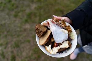 prato com sobras de pão e peixe na mão foto