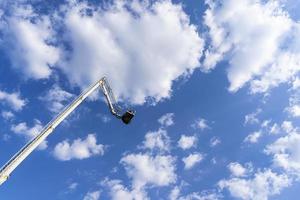 torre de carro para levantar pessoas a uma grande altura no fundo do céu azul foto