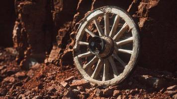 roda de carrinho de madeira velha em rochas de pedra foto