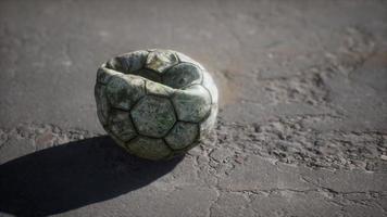 bola de futebol velha o chão de cimento foto