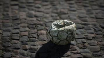 bola de futebol velha no pátio do pavimento foto