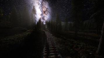 a via láctea acima da ferrovia e floresta foto