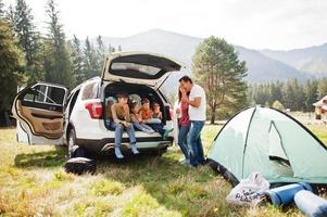 grande família de quatro filhos. crianças no porta-malas. viajando de carro nas montanhas, conceito de atmosfera. espírito americano. foto