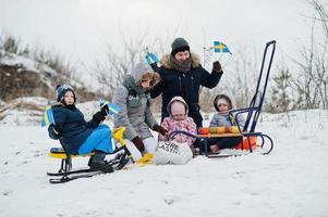 família escandinava com bandeira da suécia na paisagem sueca de inverno. foto