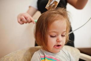 mãe com filha fazendo rotina diária juntos. mãe está escovando e secando o cabelo da criança após o banho. foto