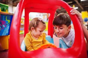 irmão com irmã jogando na piscina de bolinhas coloridas. playground interno  de creche. piscina de bolinhas para crianças. sala de jogos do jardim de  infância ou pré-escola. 5848214 Foto de stock no