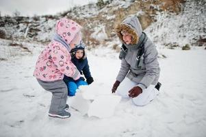 família brinca no inverno ao ar livre, mãe e filhos se divertindo. foto