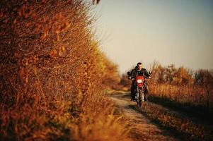 piloto de enduro sentado em sua moto foto