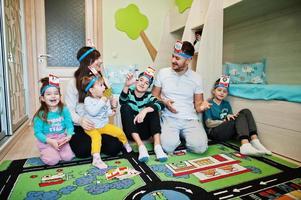 família feliz com quatro filhos jogando adivinha quem enquanto se diverte em casa. foto