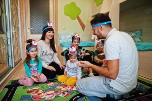 família feliz com quatro filhos jogando adivinha quem enquanto se diverte em casa. foto