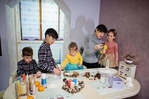 mãe com quatro filhos faz uma guirlanda para a véspera de natal e decoração de artesanato. celebração de Ano Novo. foto