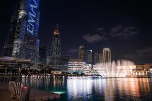 arranha-céu burj khalifa à noite em dubai. belas fontes em frente ao burj khalifa. foto