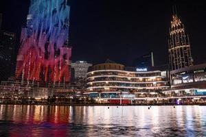 arranha-céu burj khalifa à noite em dubai. belas fontes em frente ao burj khalifa. foto