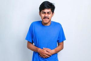 homem asiático alertando camiseta casual diarréia problemas de saúde segure sua barriga foto