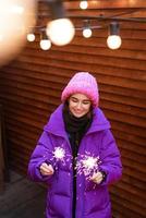 garota caucasiana está se divertindo no inverno na rua com estrelinhas na mão foto