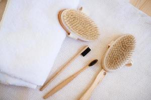 escovas de massagem de madeira natural e escovas dentais no fundo foto
