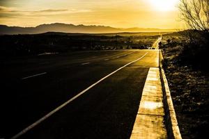 nascer do sol dourado sobre uma estrada deserta, estrada dourada foto