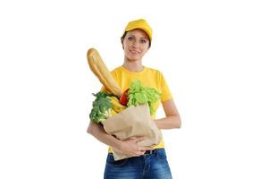 mulher de entrega sorridente em amarelo posando com sacola de compras, fundo branco foto