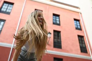 jovem feliz com movimento de cabelo no meio urbano. foto