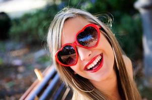 garota engraçada com óculos de coração vermelho foto