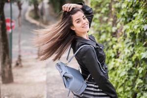 jovem mulher movendo o cabelo em meio urbano foto