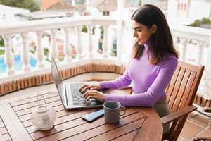 mulher persa em sua varanda usando computador portátil
