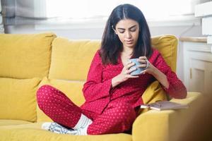 mulher em casa tomando chá e lendo foto