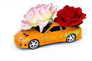 carro de brinquedo com rosas no fundo branco foto