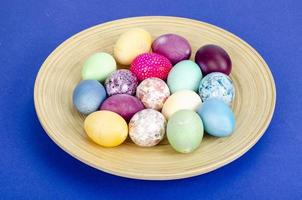 ovos de páscoa artesanais decorados para a temporada de férias em fundo azul. conceito abstrato mínimo criativo. foto de estúdio