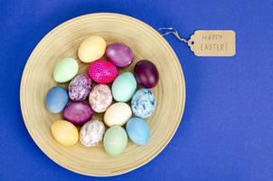 ovos de páscoa artesanais decorados para a temporada de férias em fundo azul. conceito abstrato mínimo criativo. foto de estúdio