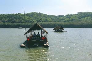 província de loei, tailândia dezembro de 2021 casal na área do reservatório de huai krathing com abrigo de jangada de bambu para rafting e alimentação. bela paisagem natural do rio e montanha com céu azul foto