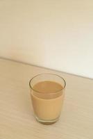 copo de café com leite com garrafas de café prontas para beber foto