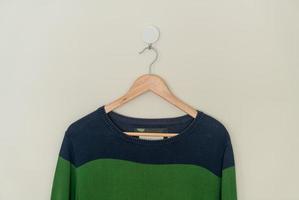 suéter colorido pendurado com cabide de madeira foto