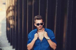 homem bonito na camisa e elegantes óculos de sol foto