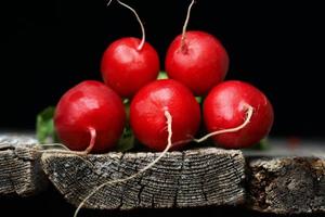 rabanete vermelho fresco na borda da velha mesa de madeira foto