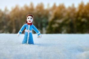 agulha de boneca artesanal feltrada de uma lã em pé no campo nevado ao ar livre foto