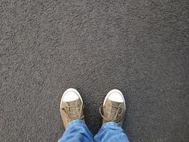 selfie de pé ou pés em sapatos de lona em pé no asfalto foto