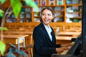 jovem e bela mulher tocando piano na aula foto